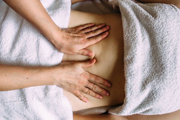 Масажистка дає масаж жіночому животу в спа-центрі
. - Фото, зображення