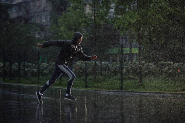 Man jogging under rain, flash light - Foto, afbeelding