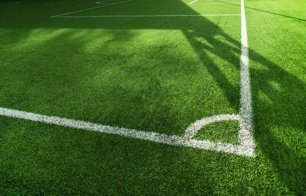緑の人工芝サッカー場と白線と日光の背景を持つサッカー場 - 写真・画像
