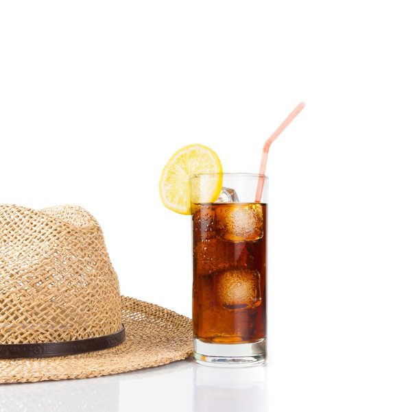 glass of fresh coke with straw near summer hat, summer time - Photo, Image