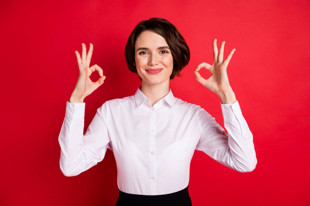 Фотопортрет щасливої ділової жінки, що показує добре жест, посміхаючись обома руками ізольований яскраво-червоний кольоровий фон
 - Фото, зображення