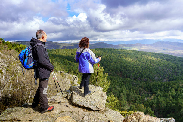 Pareja de excursionistas contemplando el paisaje desde la cima de la montaña. Guadarrama Madrid. - Foto, Imagen