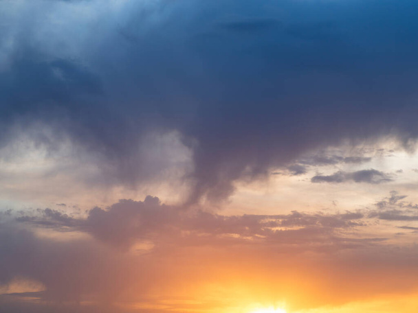 Világos sokszínű ég-felhő háttér. A nap a horizont szintjén süt, és sárga és vörös árnyalatokban színezi a felhőket. Naplemente vagy hajnal - Fotó, kép