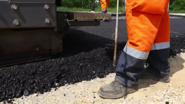 Low angle view op machine voor het leggen van asfalt, het verspreiden van laag heet asfalt op voorbereide grond. - Video