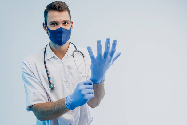 European male doctor putting latex gloves on - Foto, afbeelding