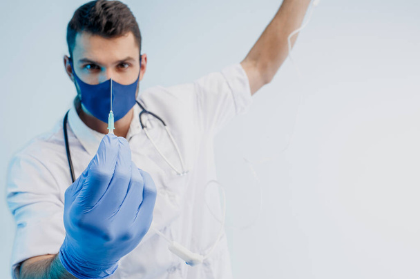 Médico varón europeo mostrando jeringa en estudio - Foto, imagen