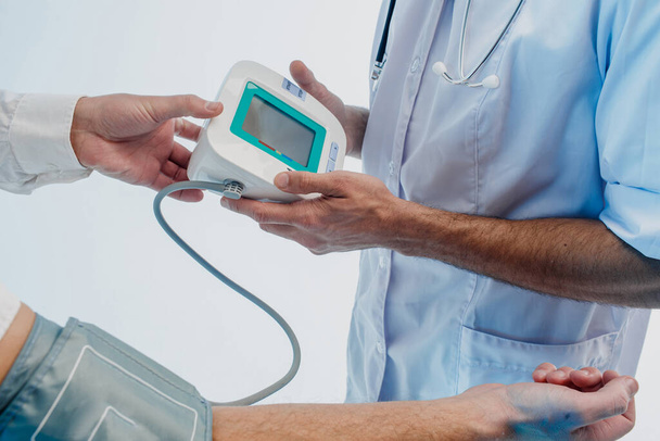 Doctor check pulse of patient with tonometer - Fotó, kép