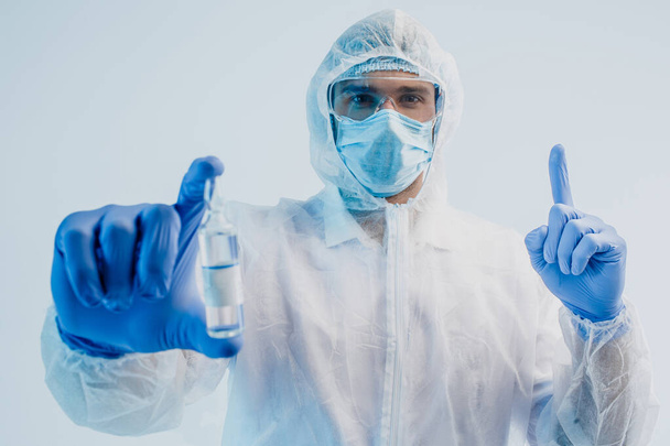 Άνδρας γιατρός δείχνουν COVID-19 εμβόλιο και χειρονομία ιδέα - Φωτογραφία, εικόνα