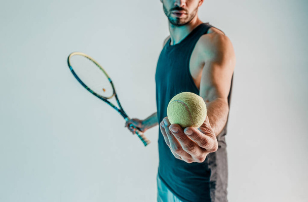 スポーツマンは手にテニスボールを保持し、示す - 写真・画像