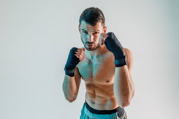 Young bearded european boxer is boxing in studio - Photo, Image