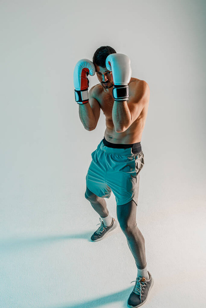 Concentrated european boxer is boxing in studio - 写真・画像