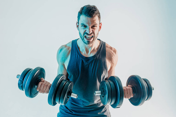 Jeune homme entraînement biceps muscles avec haltères - Photo, image