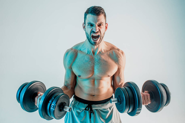 Mladý muž trénink biceps svaly s činkami - Fotografie, Obrázek