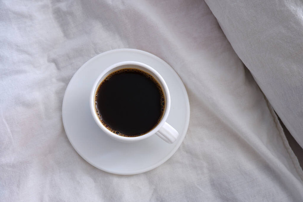 White cup of black coffee in a white bed. - Foto, immagini