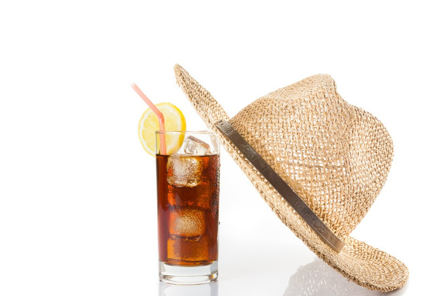 glass of fresh coke with straw near summer hat on top, summer time - Φωτογραφία, εικόνα