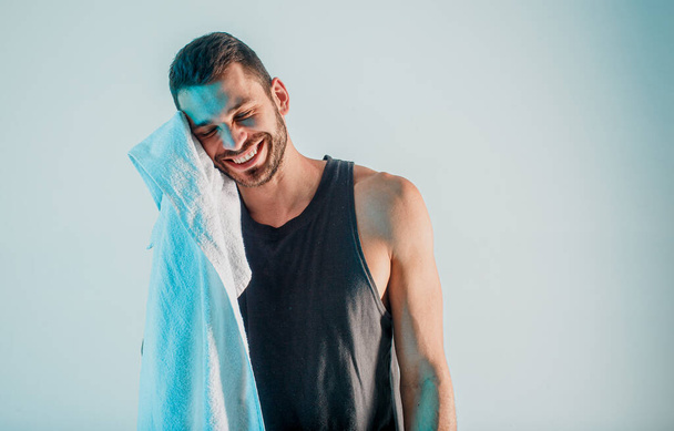 Hymyilevä urheilija pyyhkii pyyhkeellä harjoittelun jälkeen - Valokuva, kuva