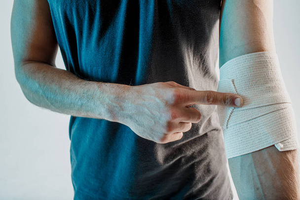 Sportler wickeln medizinische Binde im Studio an der Hand - Foto, Bild