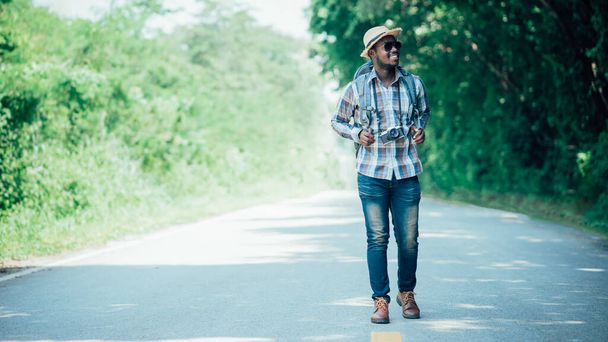 Matkustaa afrikkalainen mies turisti reppu kävely valtatie road.Adventure matkustaa käsite - Valokuva, kuva