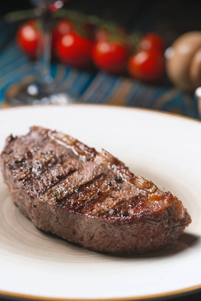 Grilled steak ,cherry tomatoes salt and pepper on wooden table. - Photo, Image