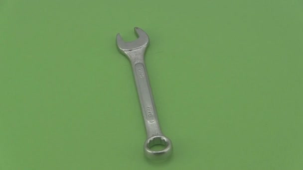 Chrome spanner rotating on a green  background. - Footage, Video