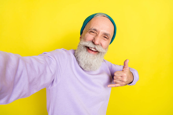 Photo portrait of elder man showing heavy metal gesture laughing isolated on vivid yellow color background - Zdjęcie, obraz