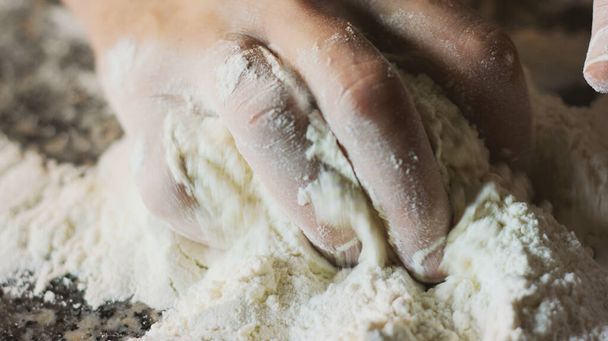 hand squeezes flour for bread and pizza - Zdjęcie, obraz