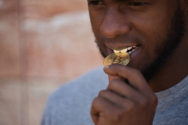 Африканський американець, який гризе біткоїн криптовою валютою з зубами в кишені.. - Фото, зображення