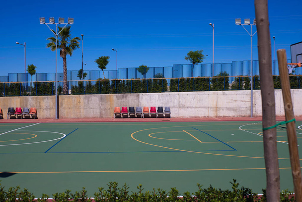 Detail of the university sports courts after classes when they are completely empty. You can see the chairs for the reserves of each sports team. - Foto, imagen