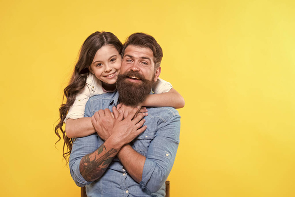 Love is main ingredient. Happy daughter hug father with love. Bearded man and little child. Happy family yellow background. Relationship and relations. Rooted and grounded in love. Trust and care - Foto, Imagen
