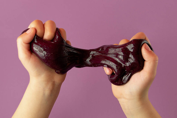 Child playing with purple slime in hands,top view. - Photo, image