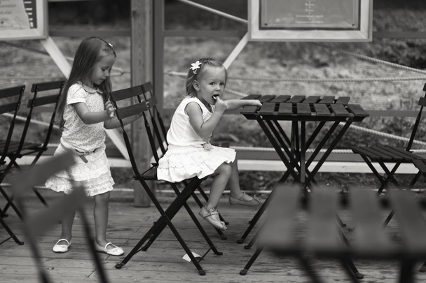 Little happy girls have fun at outdoor cafe - Photo, Image
