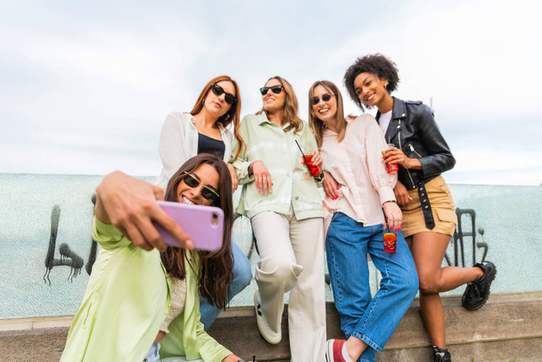 Felice gruppo di donne con occhiali da sole, scattare selfie con smartphone nella giornata di sole. Amicizia concetto. - Foto, immagini