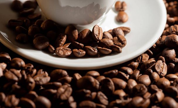 Checker mit Espressokaffee auf Untertasse und Kaffeekörnern  - Foto, Bild