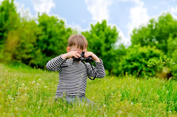 Kleiner Junge scannt mit Fernglas den Wald - Foto, Bild