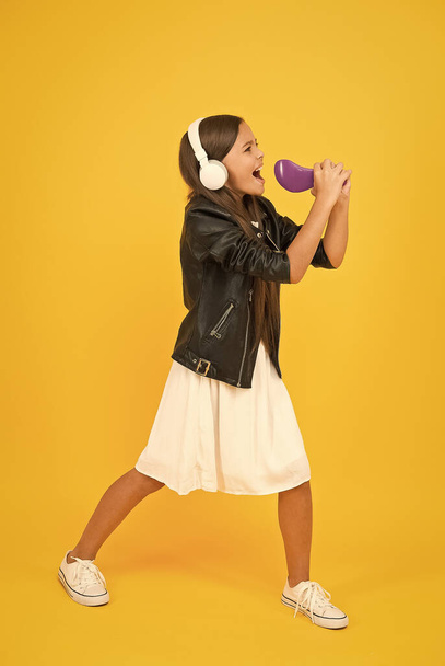 Hairbrush mic. Listening music. Girl with headphones. Hobby concept. Happy child in earphones. Audio concept. Kid enjoy modern music. Buy new music device. Imaginary stage. Sing like a rock star - Foto, Imagen