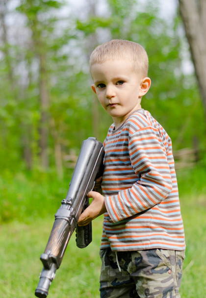 Lindo chico apuntando con ametralladora
 - Foto, Imagen