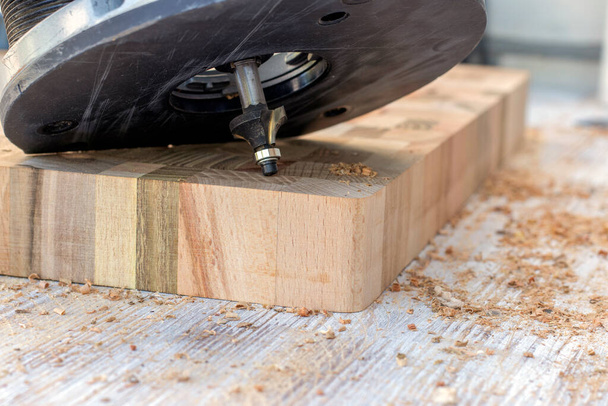 Machining with an electric wood plank router, hand-held router close-up. Selective focus. - Фото, изображение