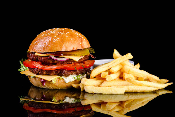 Delicious hamburger, served burger with french fries on a black background - Foto, Imagem