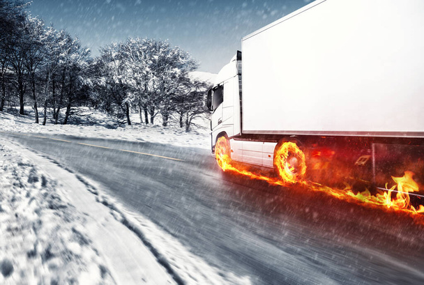 Camión blanco con ruedas ardientes en un camino cubierto de nieve - Foto, imagen