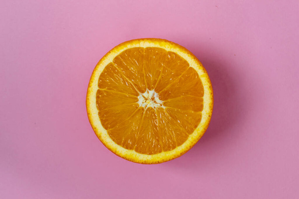 Top view of one orange round fruit on bright blue background. Rich citrus texture. Copy space. - Foto, afbeelding