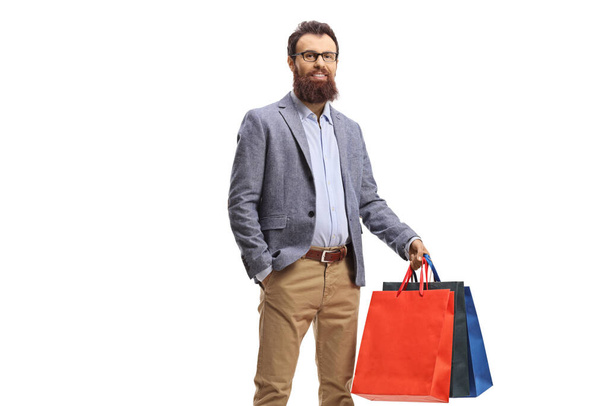 Young bearded man holding shopping bags isolated on white background - Photo, image