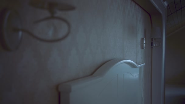 In een slaapkamer, een man zet de lamp naast het hoofd van het bed - Video