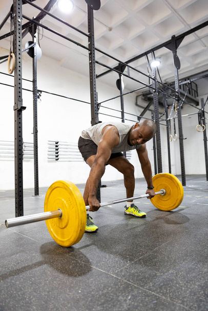 Atleta masculino negro preparado para levantamiento de pesas en el gimnasio. Espacio para texto. - Foto, imagen