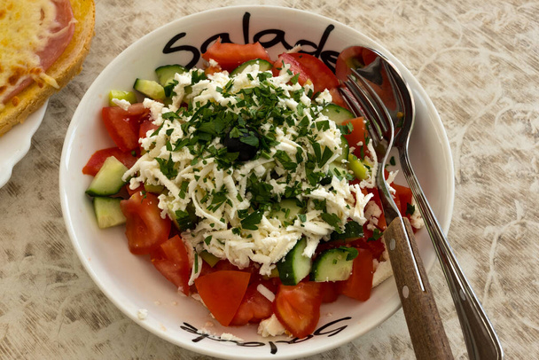 Fresh tomatoes, cucumbers topped with shredded feta cheese makes the perfect lunch in Bulgaria where it is known as Shopska salad - Foto, imagen