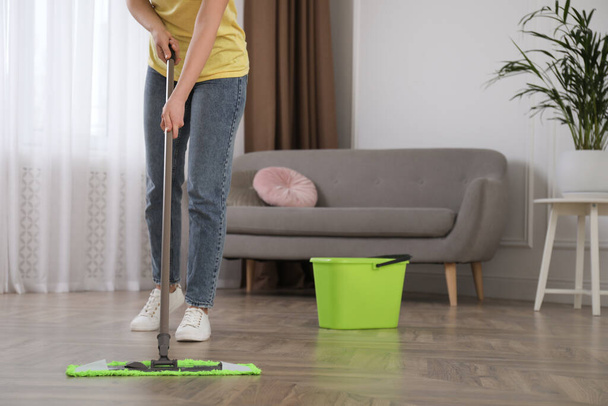 Woman cleaning floor with mop in living room, closeup - Foto, afbeelding