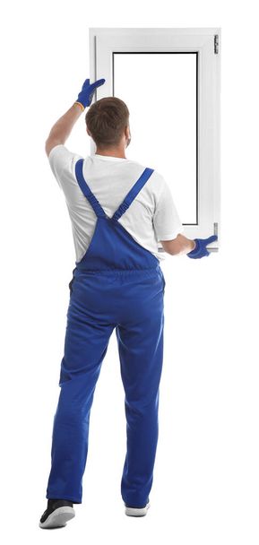 Worker with plastic window on white background, back view. Installation service - Photo, image