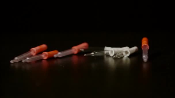 Pipettes rolling and falling on a black background, Ultra Slow Motion - Footage, Video