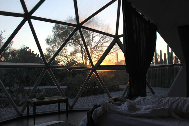 Pari makaa sängyssä katsomassa auringonnousua glamping geodeettinen teltta ikkuna - Valokuva, kuva