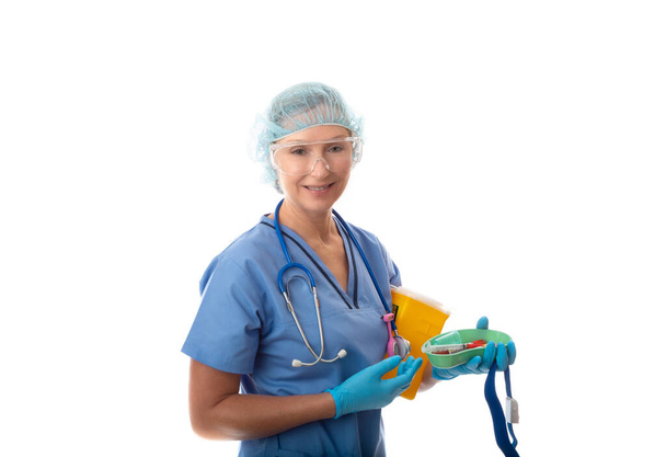 Enfermero o patólogo que sostiene tubos sanguíneos en un plato de riñón, con un contenedor de torniquete y objetos punzantes - Foto, imagen