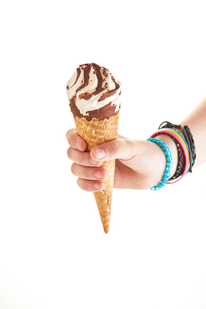 Holding ice cream with chocolate in cone in hand isolated on white background. - Foto, immagini